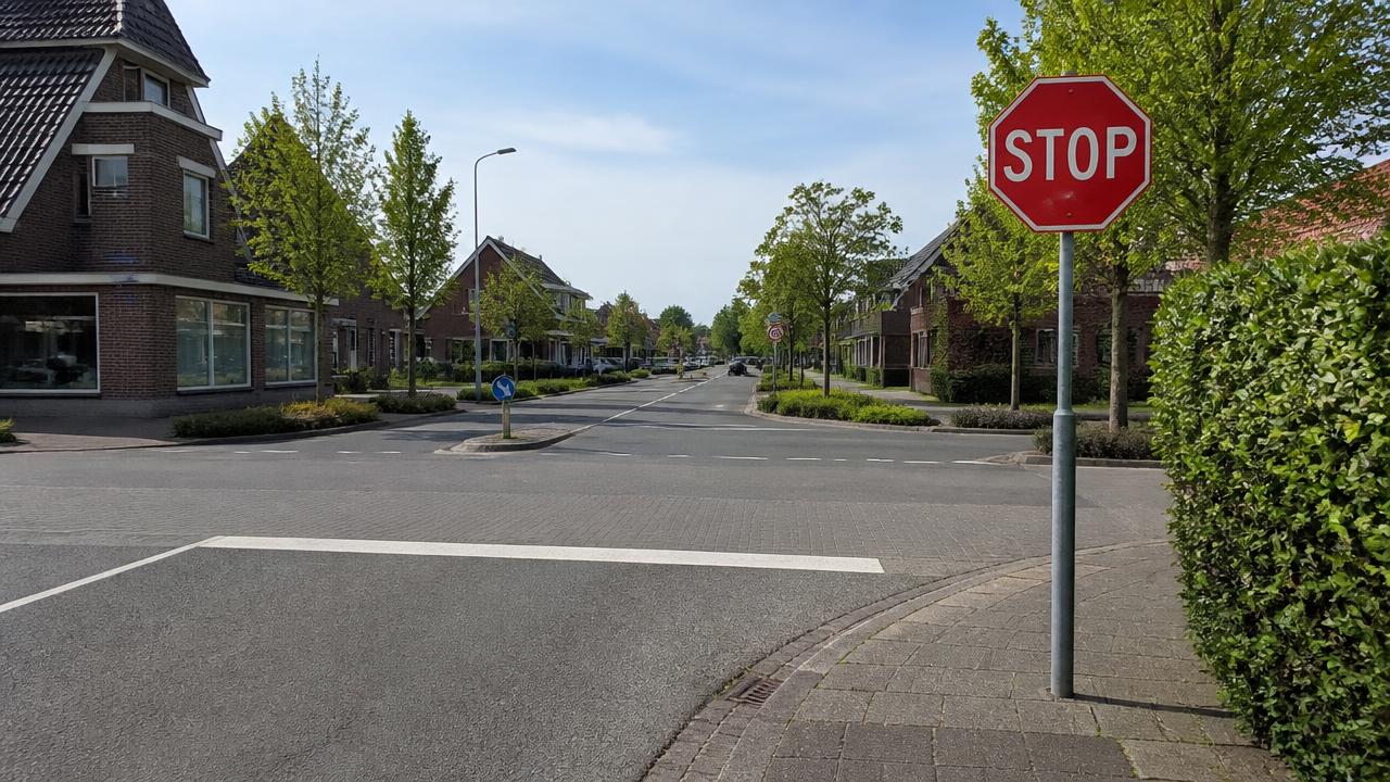 Nederlands kruispunt met verkeersbord B7 (STOP) en witte stopstreep