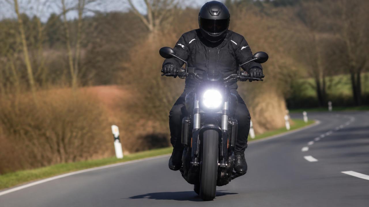 Motor met brandend dimlicht overdag op een landweg