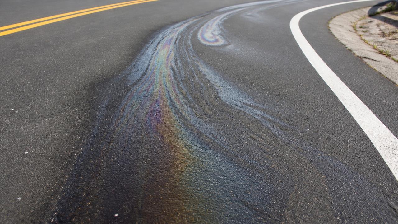 Glimmende dieselbaan met regenboogglans in een bocht